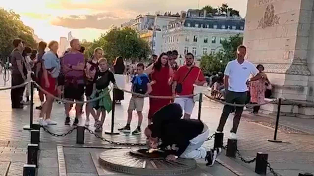 Image from video: Man lights cigarette at war memorial under Arc de Triomphe